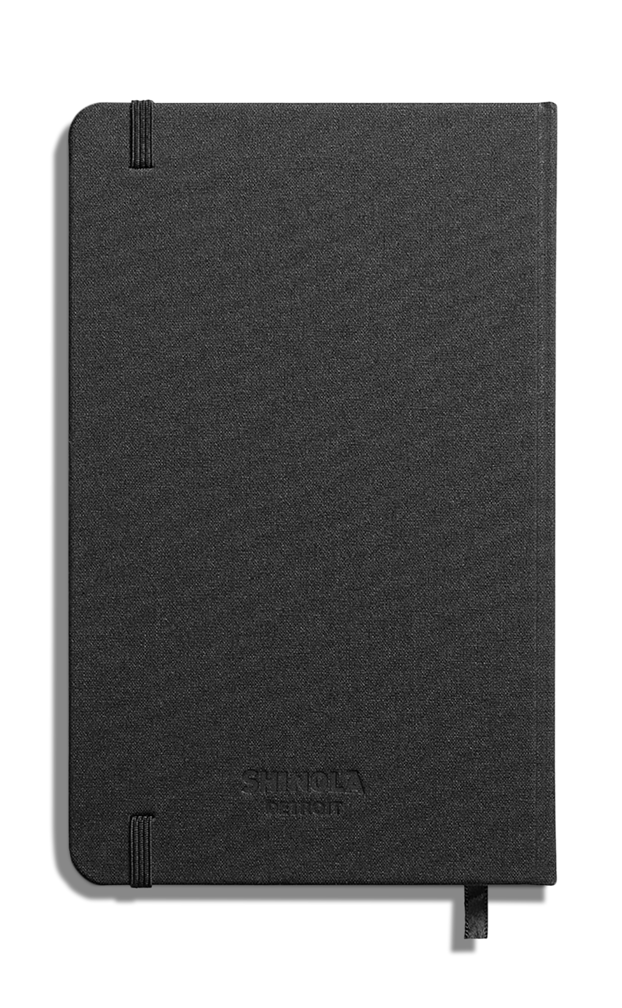 The Shinola Medium Hard Ruled Journal - Black features a closed black linen cover with elastic bands on two corners, a ribbon bookmark, acid-free paper, and the Shinola logo embossed on the front.