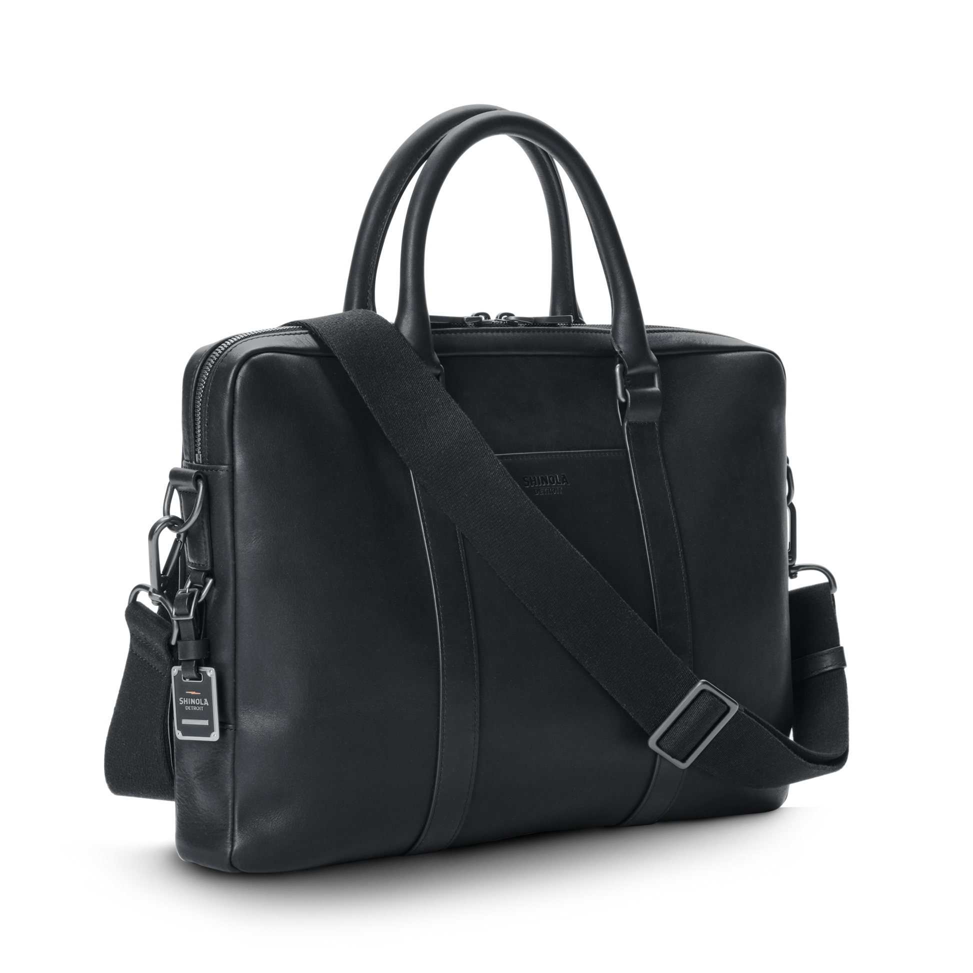 The shinola-jp.computer Briefcase - Black features double handles, a detachable shoulder strap, silver hardware, and a small branded tag, all in sleek black leather, shown against a plain white background.