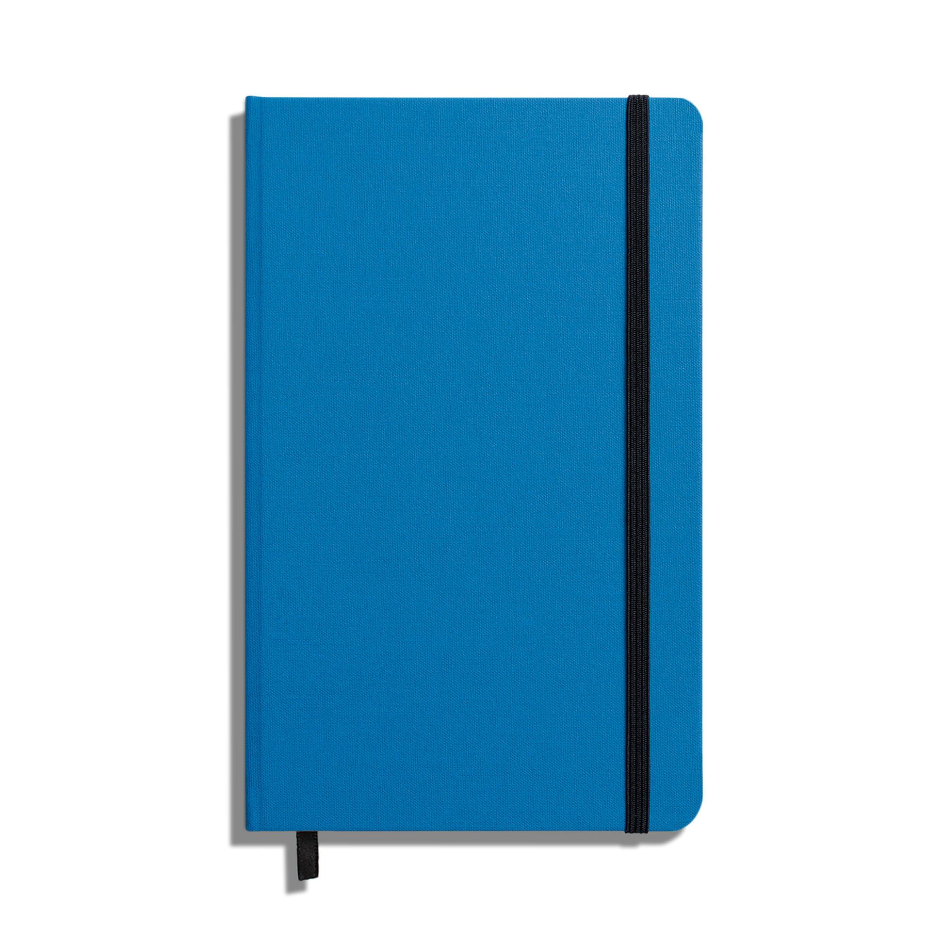 The Shinola Medium Hard Ruled Journal - Cobalt is a closed blue hardcover notebook with acid-free paper, a vertical black elastic band, and a matching ribbon bookmark, shown on a white background.