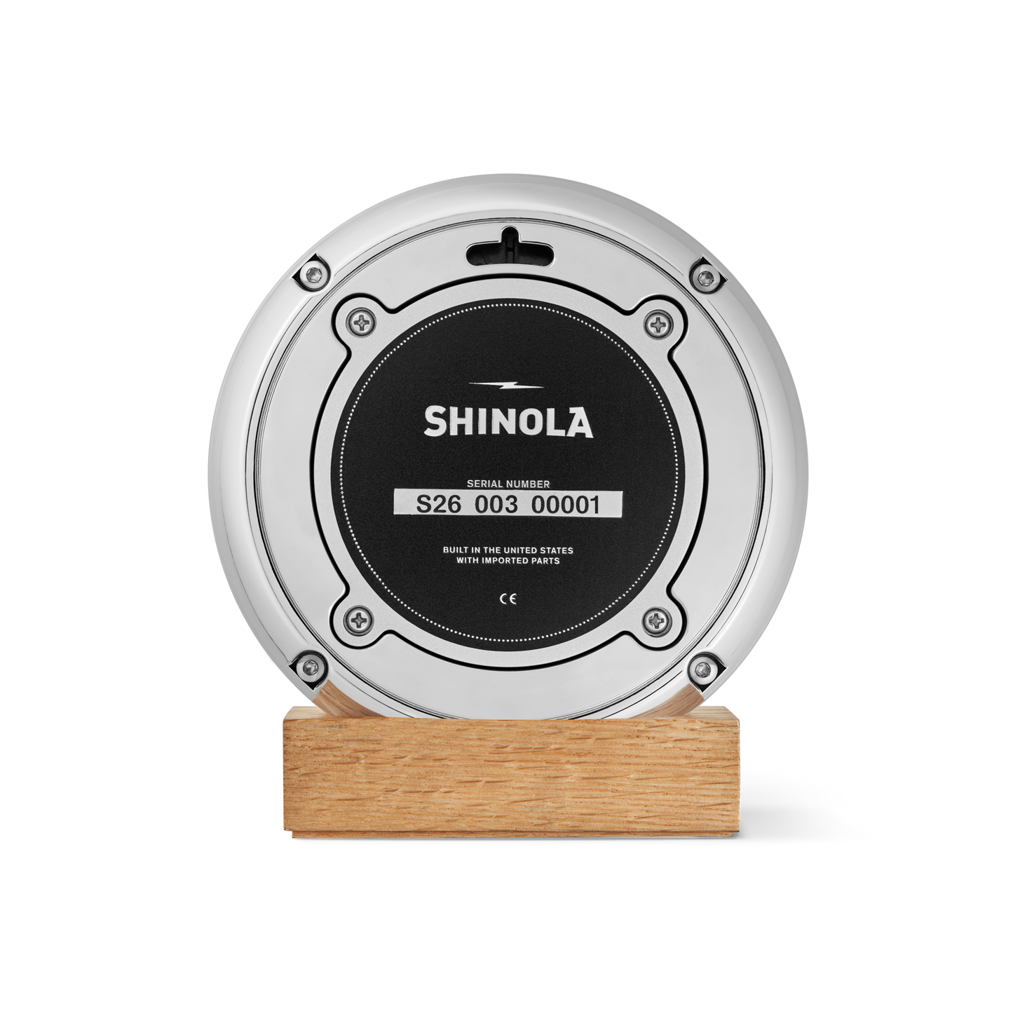 A round, silver Shinola 6" Runwell Clock with a green face, mounted on a rectangular wooden base, is photographed against a plain white background—crafted with precision at the Detroit watch factory.