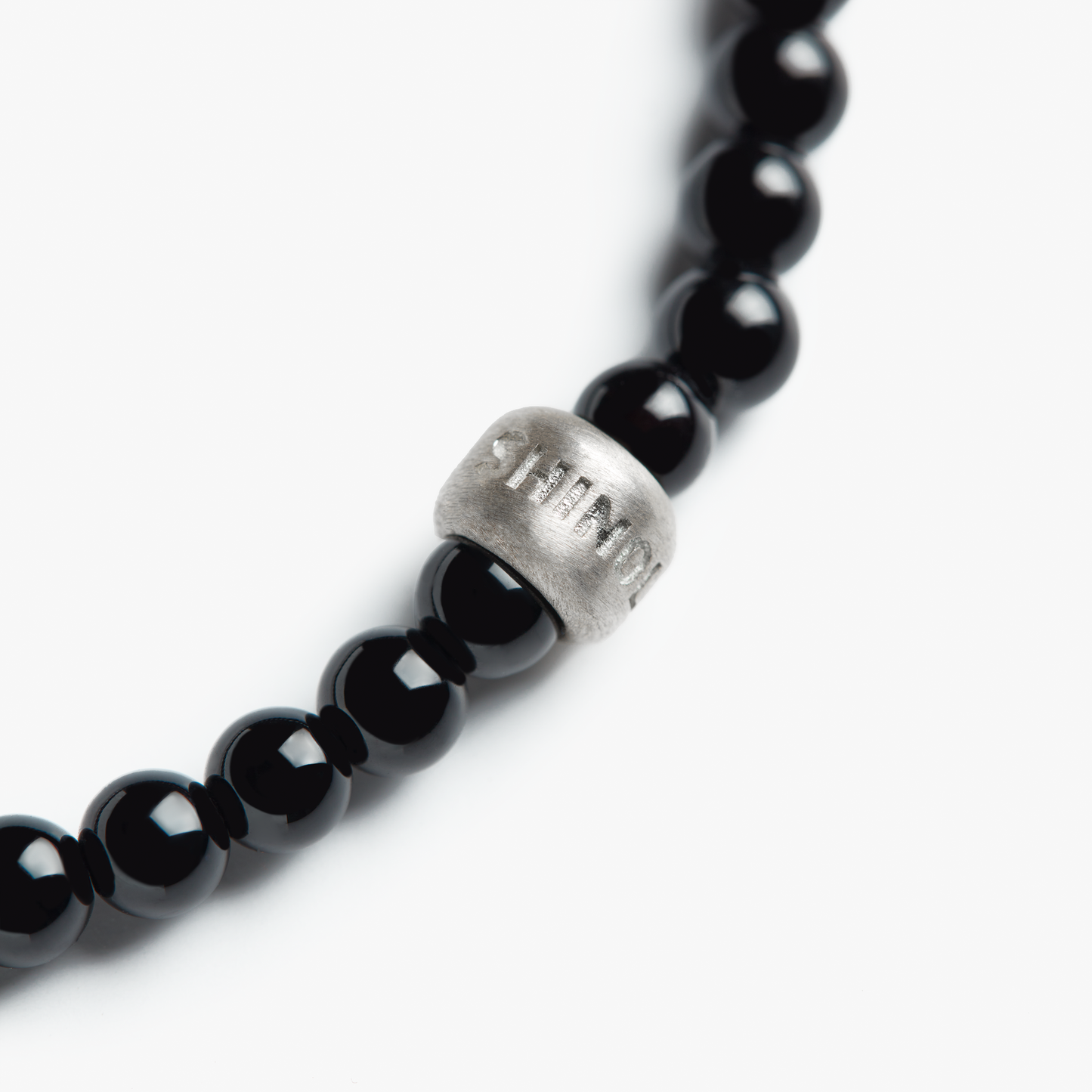 A close-up of the Shinola 4mm Beaded Onyx Bracelet, featuring onyx beads and a single sterling silver accent bead with engraved text, photographed against a white background.
