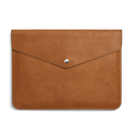 The Shinola Laptop Sleeve - Tan is crafted from natural grain leather, features a flap closure with a centered silver button, and includes an interior leather card pocket for convenience.