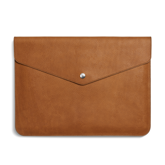 The Shinola Laptop Sleeve - Tan is crafted from natural grain leather, features a flap closure with a centered silver button, and includes an interior leather card pocket for convenience.