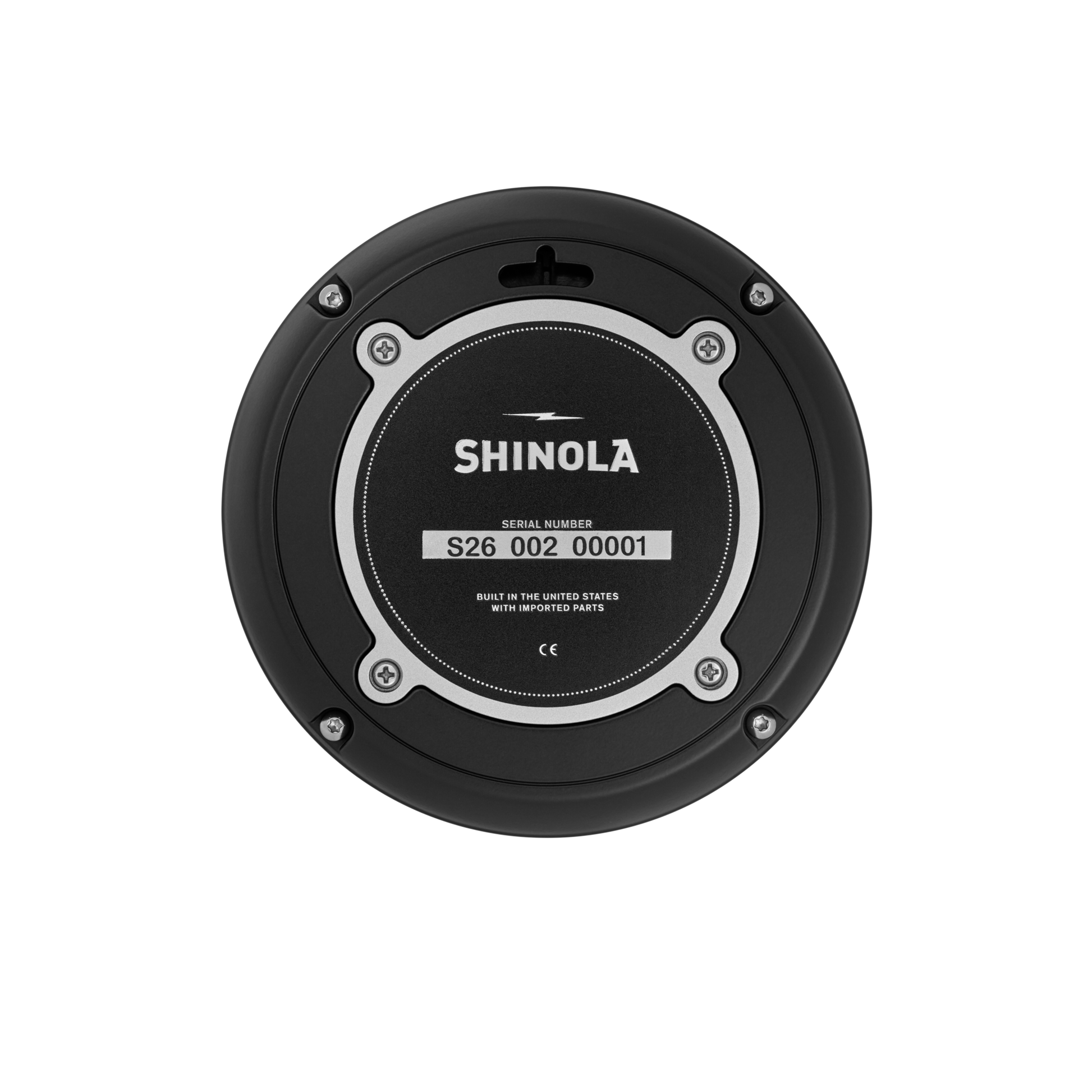 The Shinola 6" Runwell Clock - Black features a circular base with a visible serial number and the text "Built in the United States with imported parts,” evoking Detroit watch factory craftsmanship. Four screws encircle the central label.