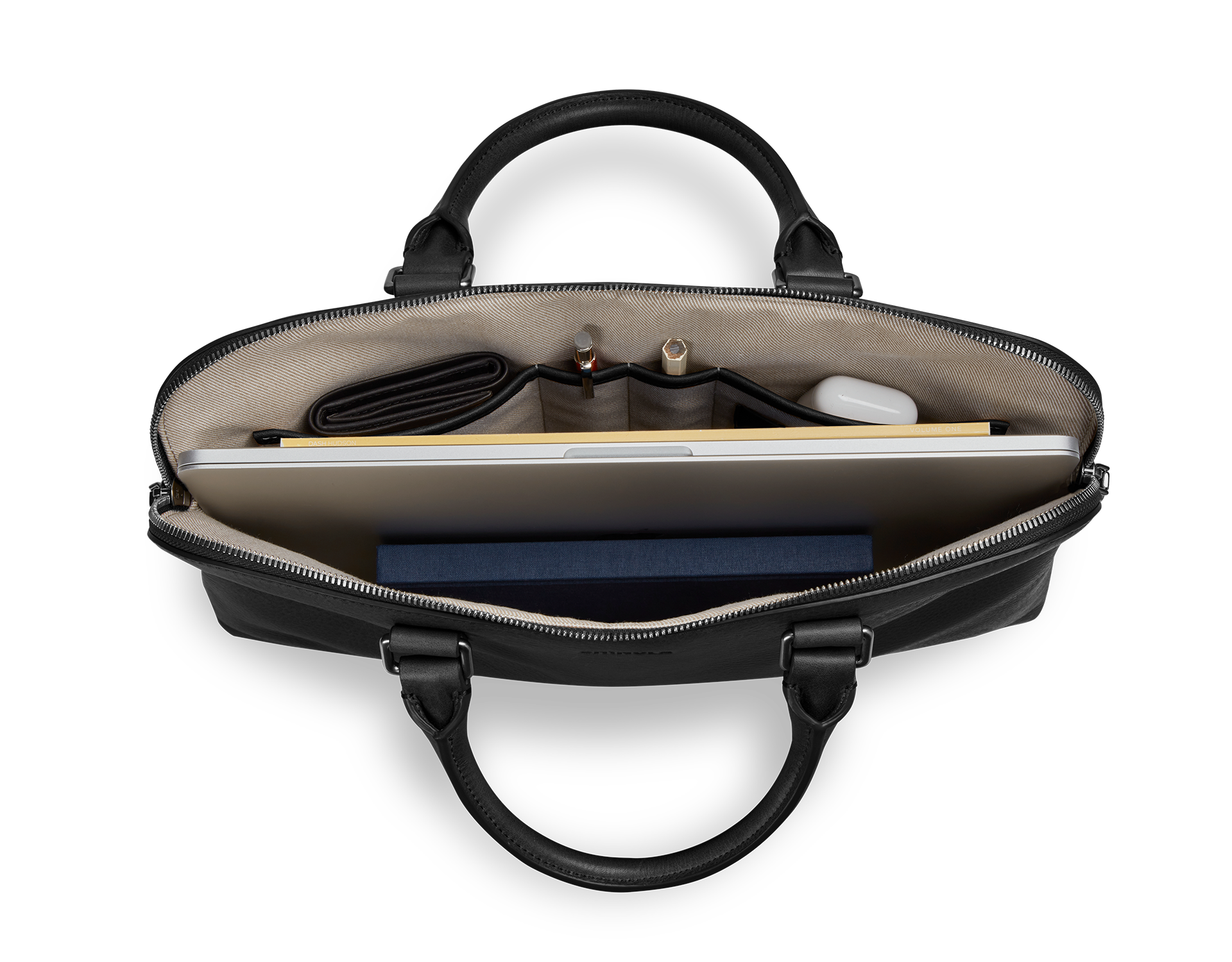 Top view of the Shinola Portfolio Briefcase - Black with a laptop, dark blue book, wallet, pens, cable, and small white item neatly arranged in beige interior compartments.