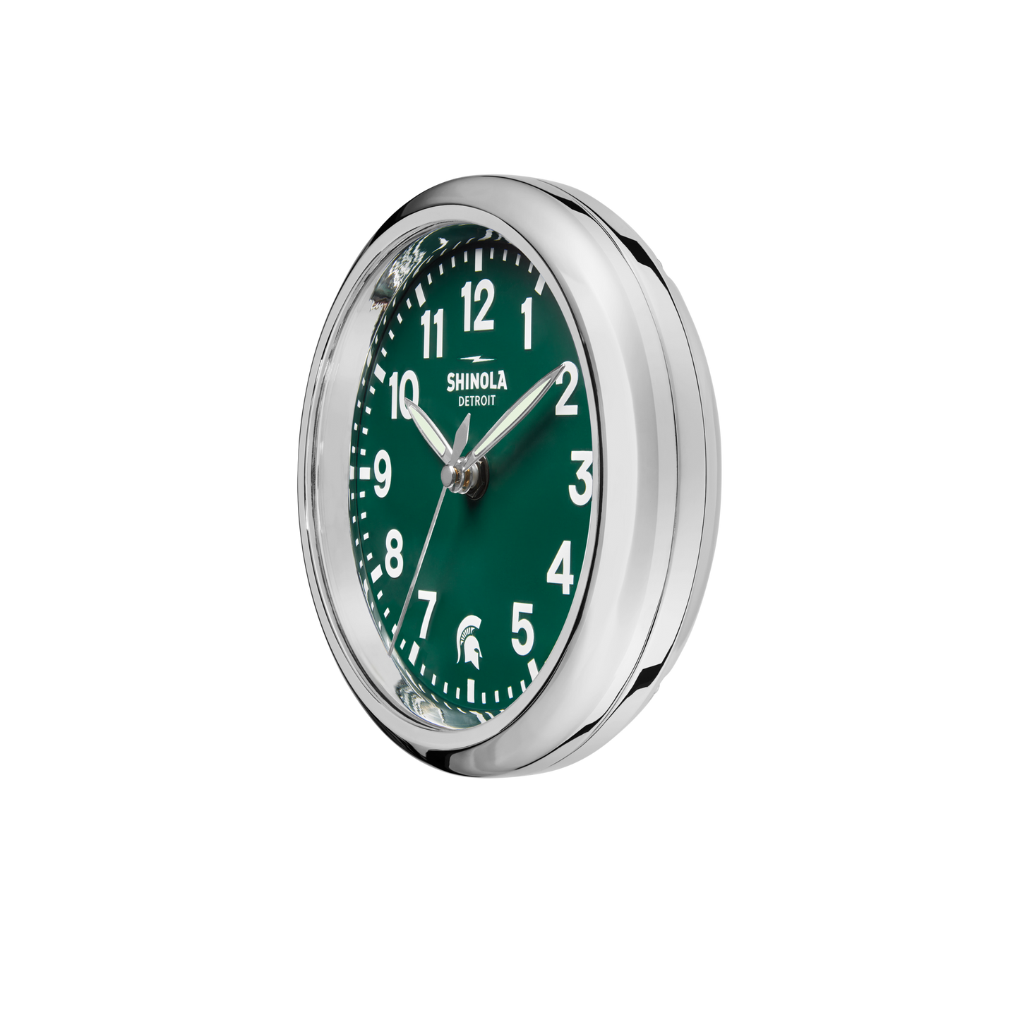 The Shinola 6" Runwell Clock - Green is a round, silver-framed desk clock with a green face, white numbers and hands, "Shinola Detroit" at the top, and a Spartan helmet logo—part of the MSU Runwell Desk Clock collection. Time shown: ~10:08.