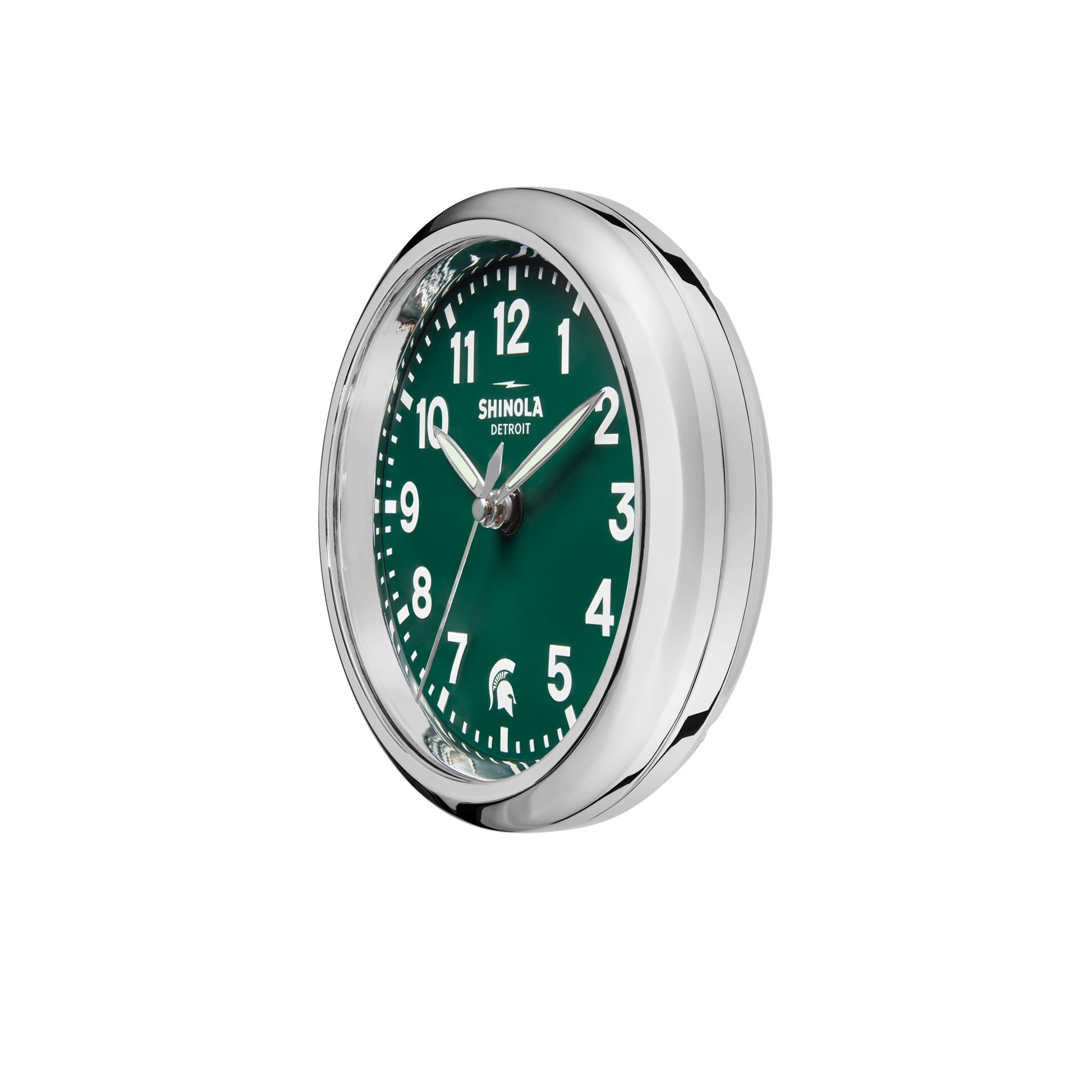 The Shinola 6" Runwell Clock - Green is a round, silver-framed desk clock with a green face, white numbers and hands, "Shinola Detroit" at the top, and a Spartan helmet logo—part of the MSU Runwell Desk Clock collection. Time shown: ~10:08.