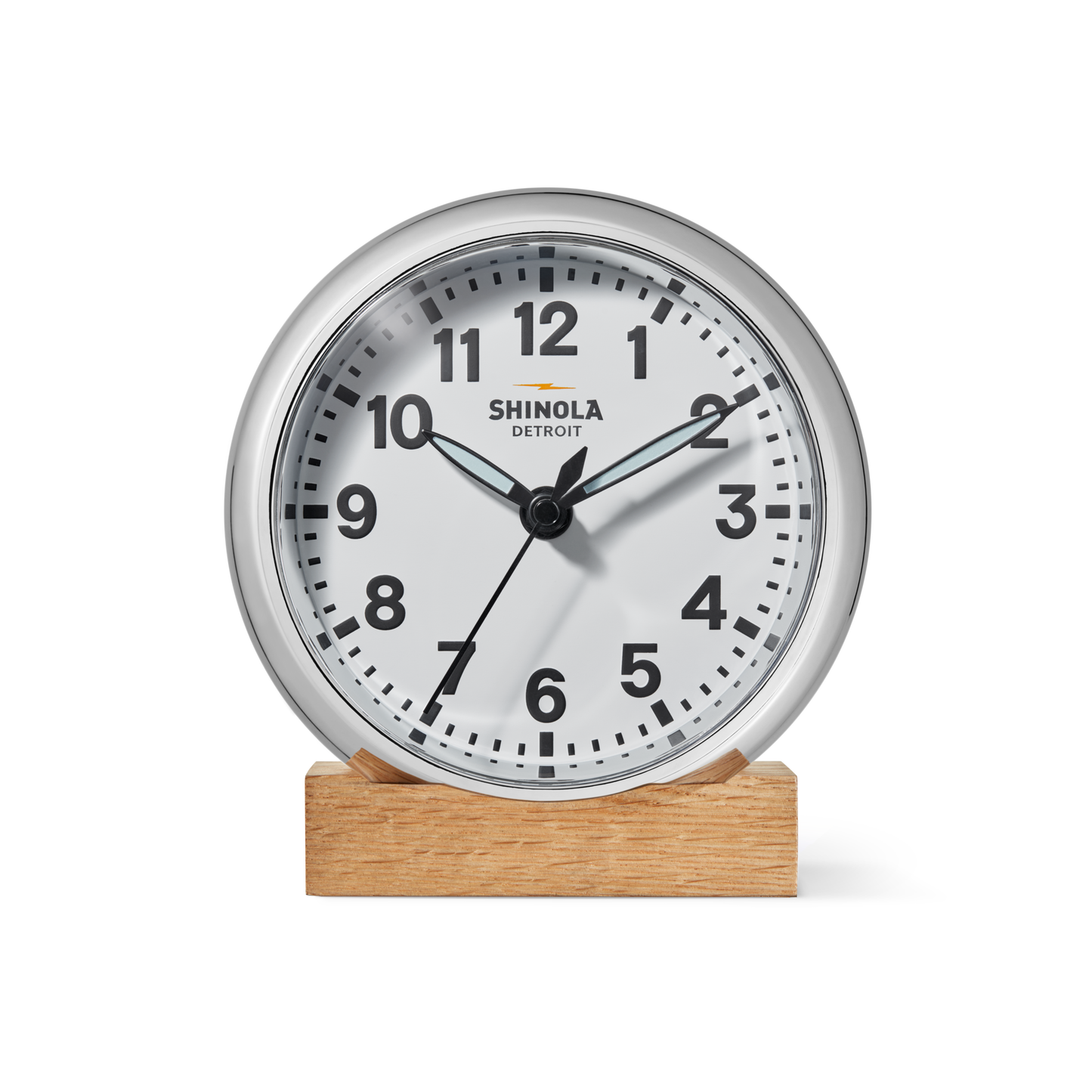 The 6" Runwell Clock - White by Shinola features a round white face, black numbers and hands, and sits on a wooden base; made in Detroit, it displays about 1:38:35 with Shinola branding on its face.