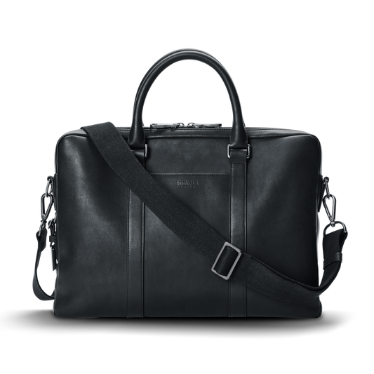 The shinola-jp.computer Briefcase - Black is a sleek leather work bag with double top handles, a detachable shoulder strap, minimal metallic hardware, and subtle front branding, shown against a plain white background.