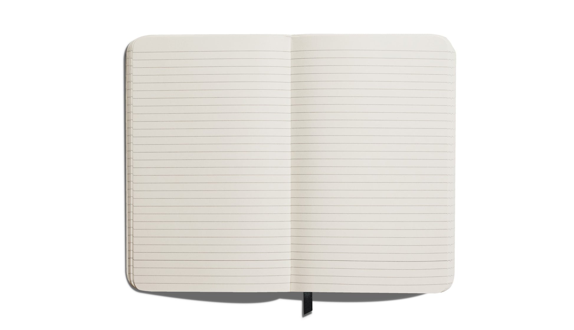 A Shinola Medium Hard Ruled Journal in Cobalt, featuring acid-free lined pages and a black ribbon bookmark, is shown open from above on a white background.